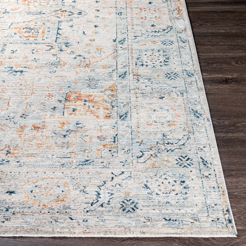 Close up of the Darvel Luxe Rug showing its cream, blue, and orange Persian-style design. Corner