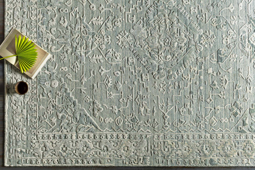 Close-up of the hand-loomed Davilla Area Rug in dark green and light gray with a traditional Persian-inspired design. Styleshot