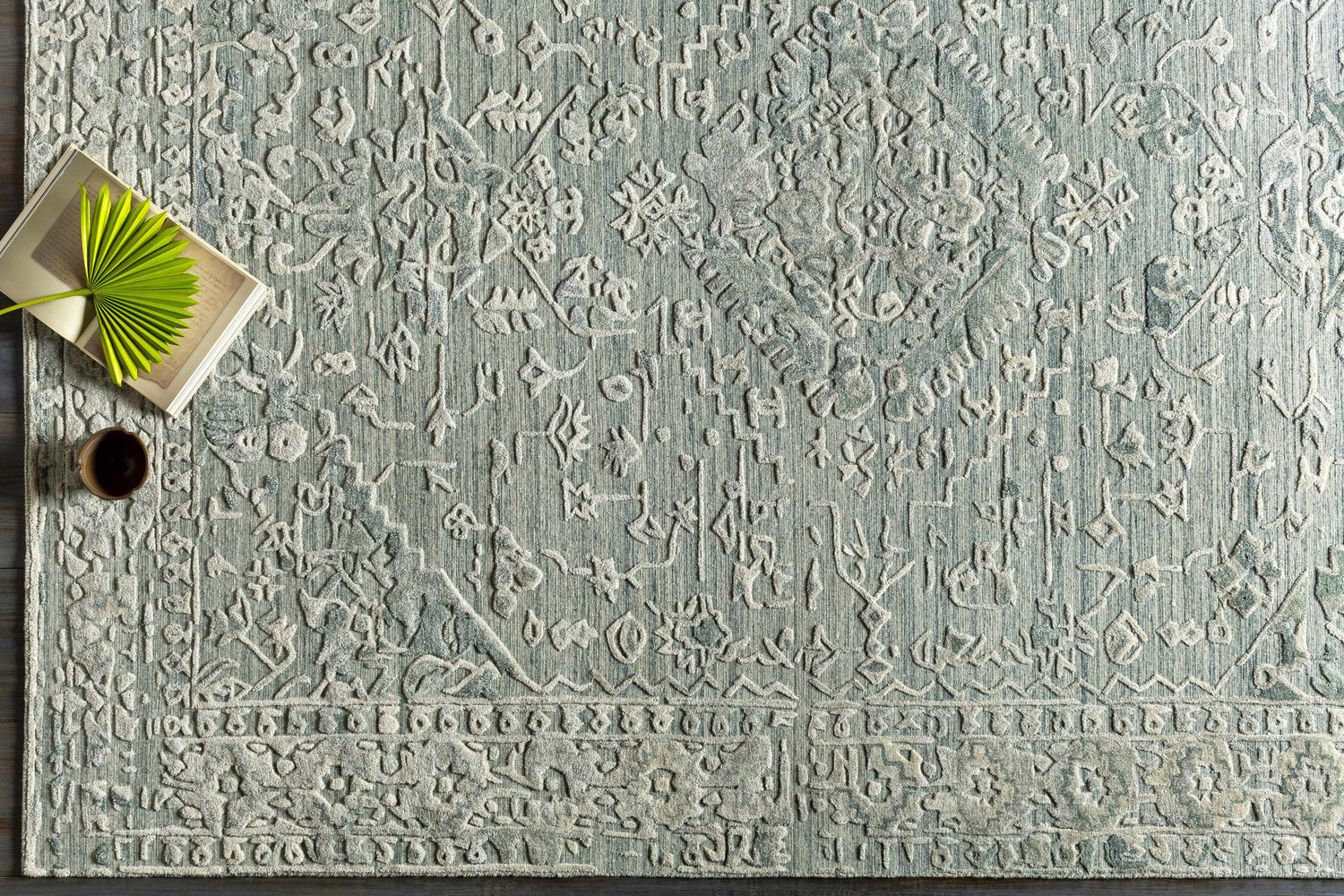 Close-up of the hand-loomed Davilla Area Rug in dark green and light gray with a traditional Persian-inspired design. Styleshot