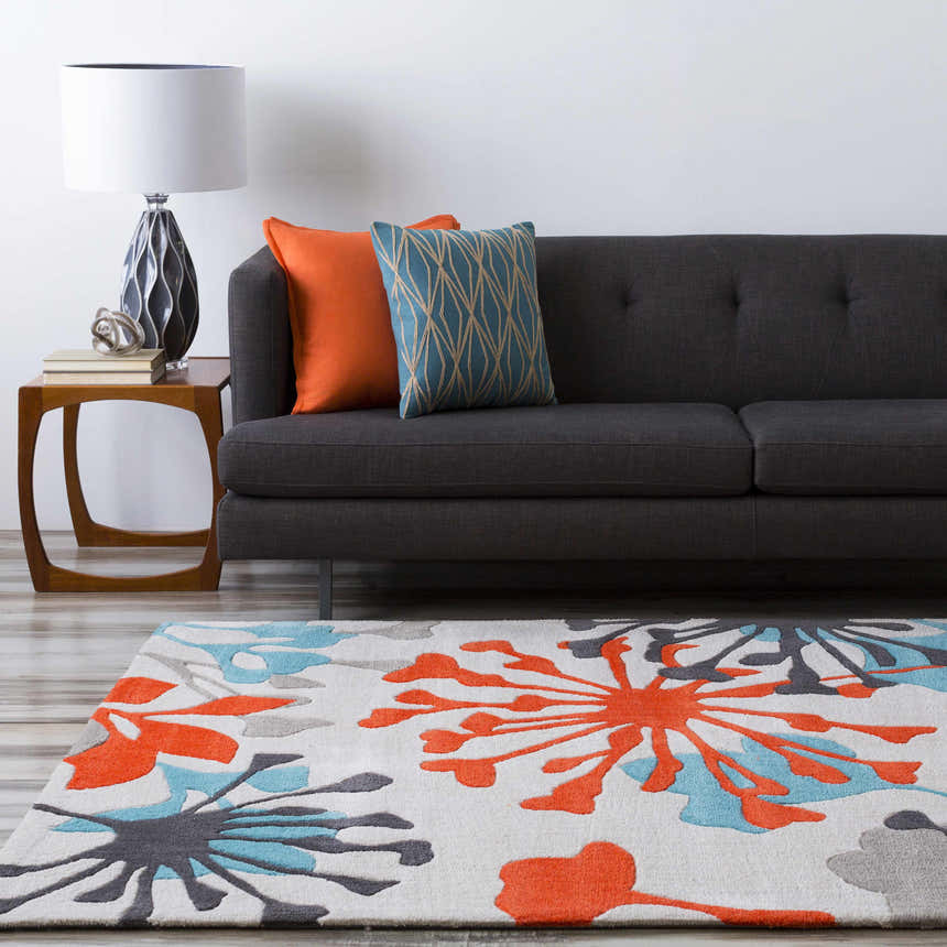 Living room scene with a gray sofa, wood side table, and the Dickens Colorful Blooming Rug in red, teal, and gray. Roomscene-Rectangle