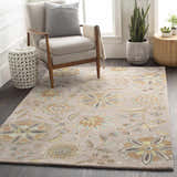 Living room scene with a floral Denio Area Rug in brown, sage, and blue tones under a chair and side tables. Roomscene-Rectangle
