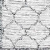 Close-up of the hand woven Dido Area Rug. Charcoal, gray, and pewter geometric pattern on a white background. Swatch