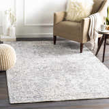 Living room scene with a neutral armchair and the blue and ivory Dingwall Carved Statement Rug. Roomscene-Rectangle