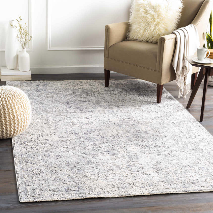 Living room scene with a neutral armchair and the blue and ivory Dingwall Carved Statement Rug. Roomscene-Rectangle
