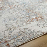 Close-up of the Dinos Thick Luxe Rug, showing its gray, nutmeg, and light blue abstract pattern and plush texture. Texture