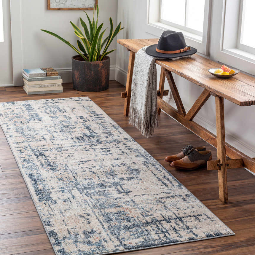 Entryway scene with a blue and ivory Dalama Area Rug, wood bench, hat, and shoes. Roomscene-Runner