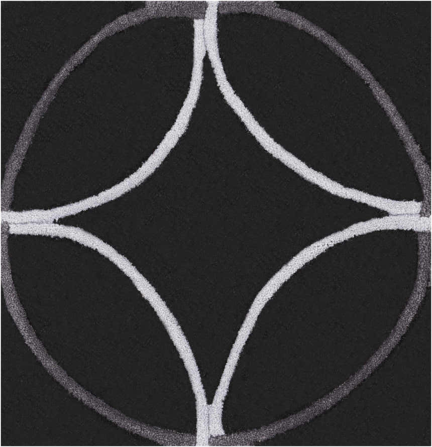Close-up of the hand-tufted Delano Area Rug. Black rug with light gray geometric circle and diamond pattern. Swatch