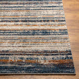Close-up of Dumaguil Thick Luxe Rug showing blue, brown, and cream horizontal stripes on a wood floor. Front