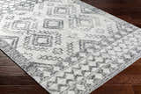 Close-up of the Adan Area Rug in arctic stone and dark gray, featuring a geometric pattern and hand-woven texture. Corner