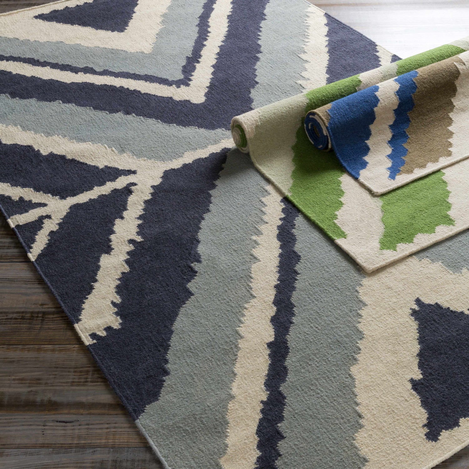 Close-up of the Doncaster Area Rug. Hand woven wool rug in charcoal, dark blue, and light beige with a contemporary pattern. Roomscene-Rectangle