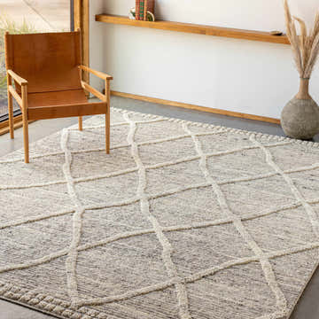 Neutral living room scene with a brown leather chair on a cream Donsol Area Carpet with a geometric pattern. Roomscene-Rectangle