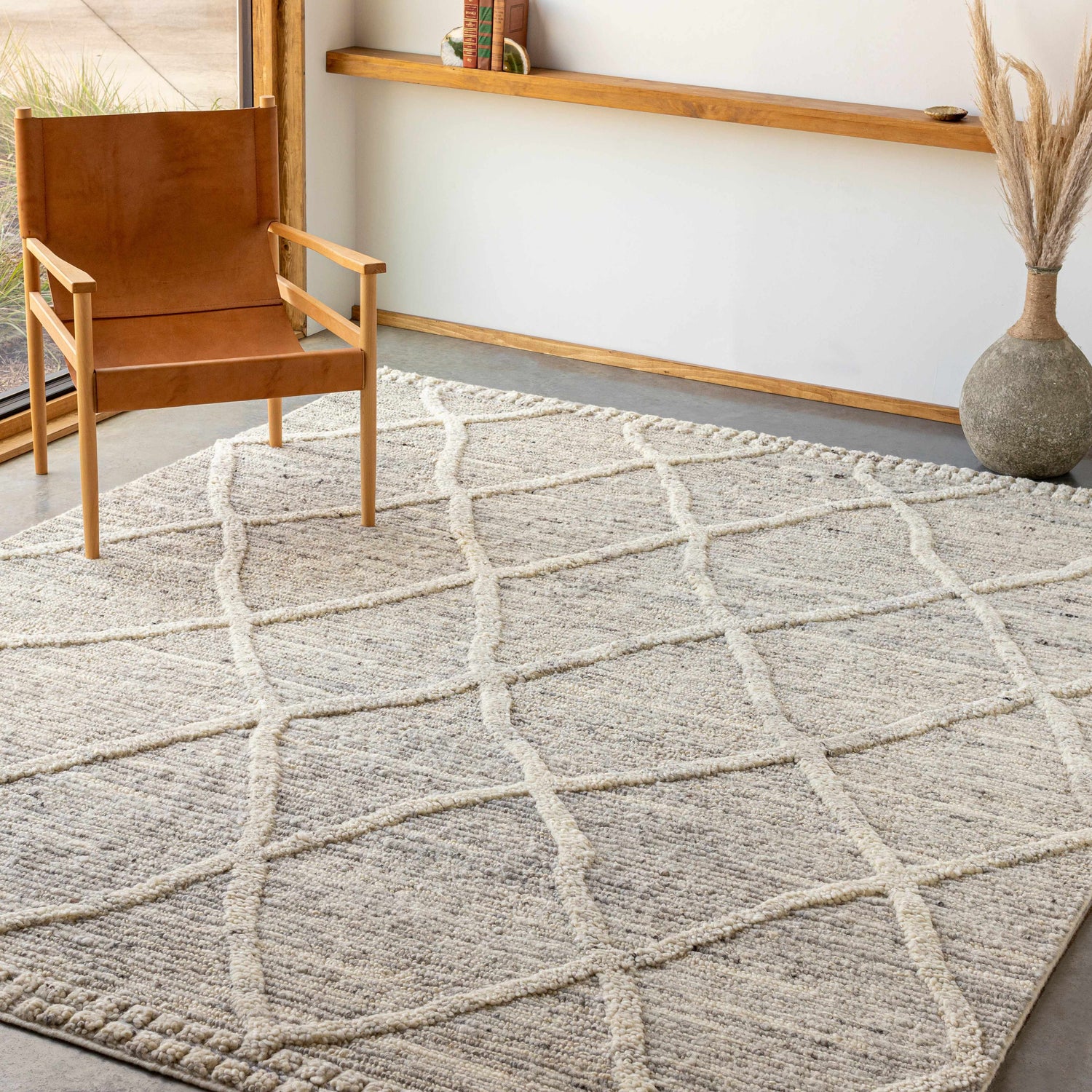 Neutral living room scene with a brown leather chair on a cream Donsol Area Carpet with a geometric pattern. Roomscene-Rectangle