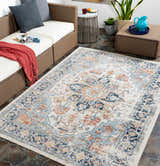 Outdoor patio scene with a Dorval Traditional Rug in brick red, cream, and denim. Wicker furniture and slate tile flooring. Roomscene-Rectangle