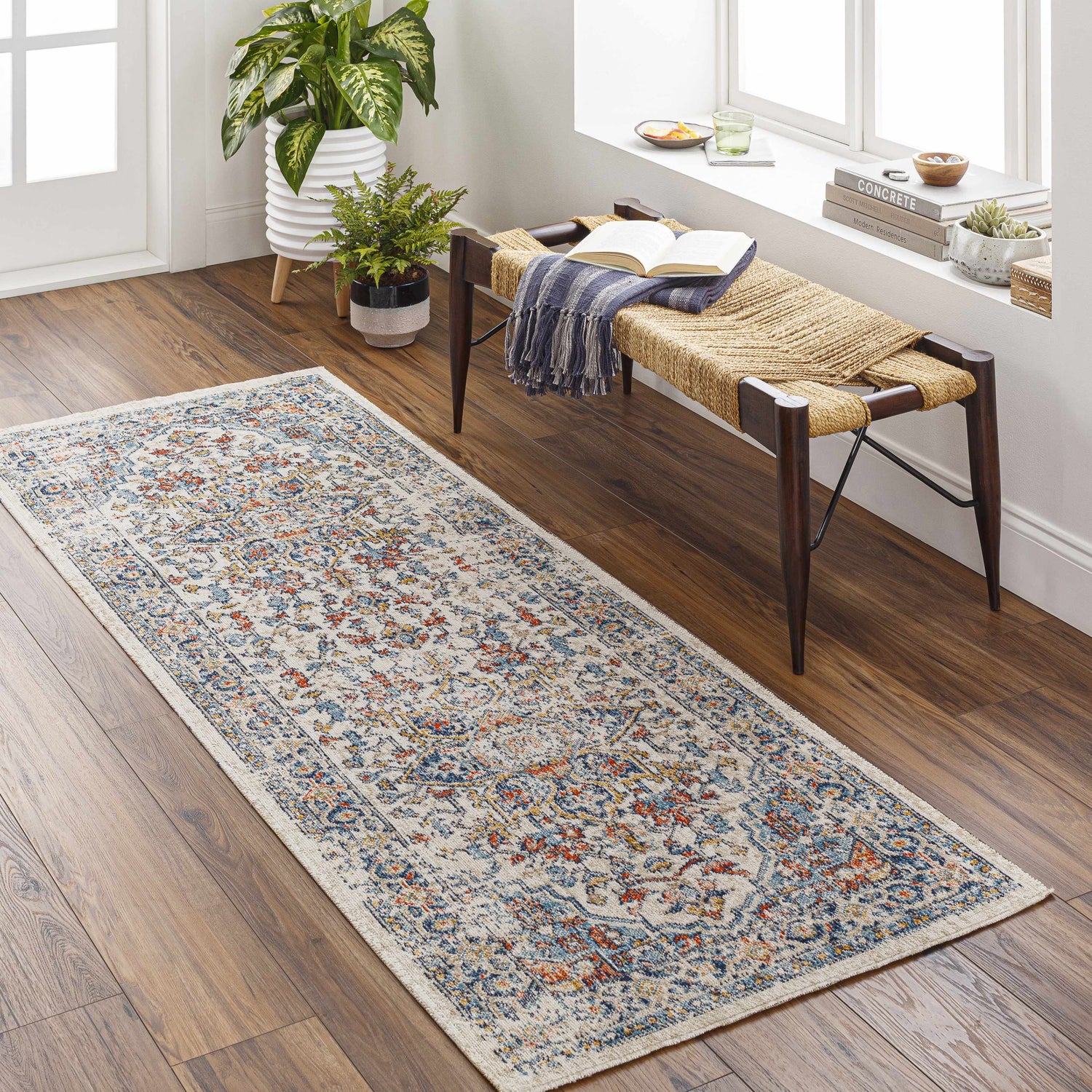 Entryway with Dorval Traditional Rug runner in brick red, cream, and denim. Bench with books and plants. Roomscene-Runner