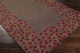 Close-up of the Dovercourt Clearance Rug. The rug is brown with a brick red and mustard leaf pattern border. Corner