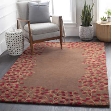 Living room scene with a brick red and brown Dovercourt Clearance Rug, gray chair, and plants. Roomscene-Rectangle