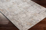 Close-up of Dowell Luxe Textured Area Rug on dark wood floor. Abstract design in gray, off-white, and mustard. Corner