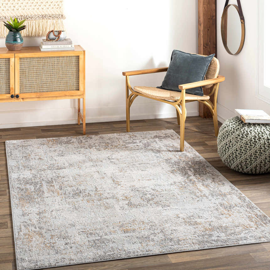 Living room scene with a Dowell Luxe Textured Area Rug in gray, brown, and mustard tones. Rattan chair and cabinet add a mid-century modern vibe. Roomscene-Rectangle
