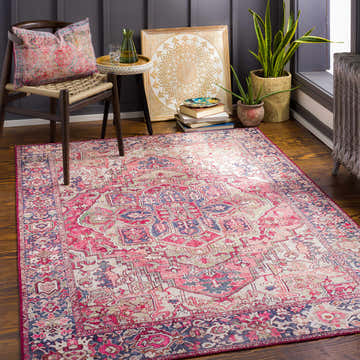 Cozy living room scene with a Neyland Iris Blush Area Rug, chair, plants, and decorative accents. Roomscene-Rectangle
