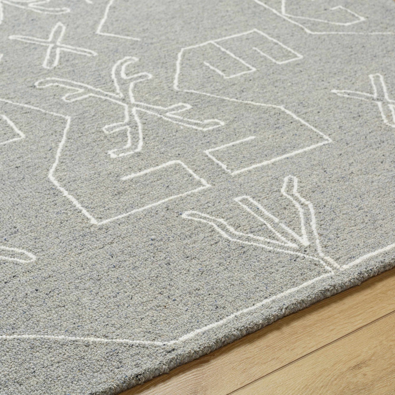 Close up of the Duard Modern Wool Rug in light gray with a white geometric pattern. Texture