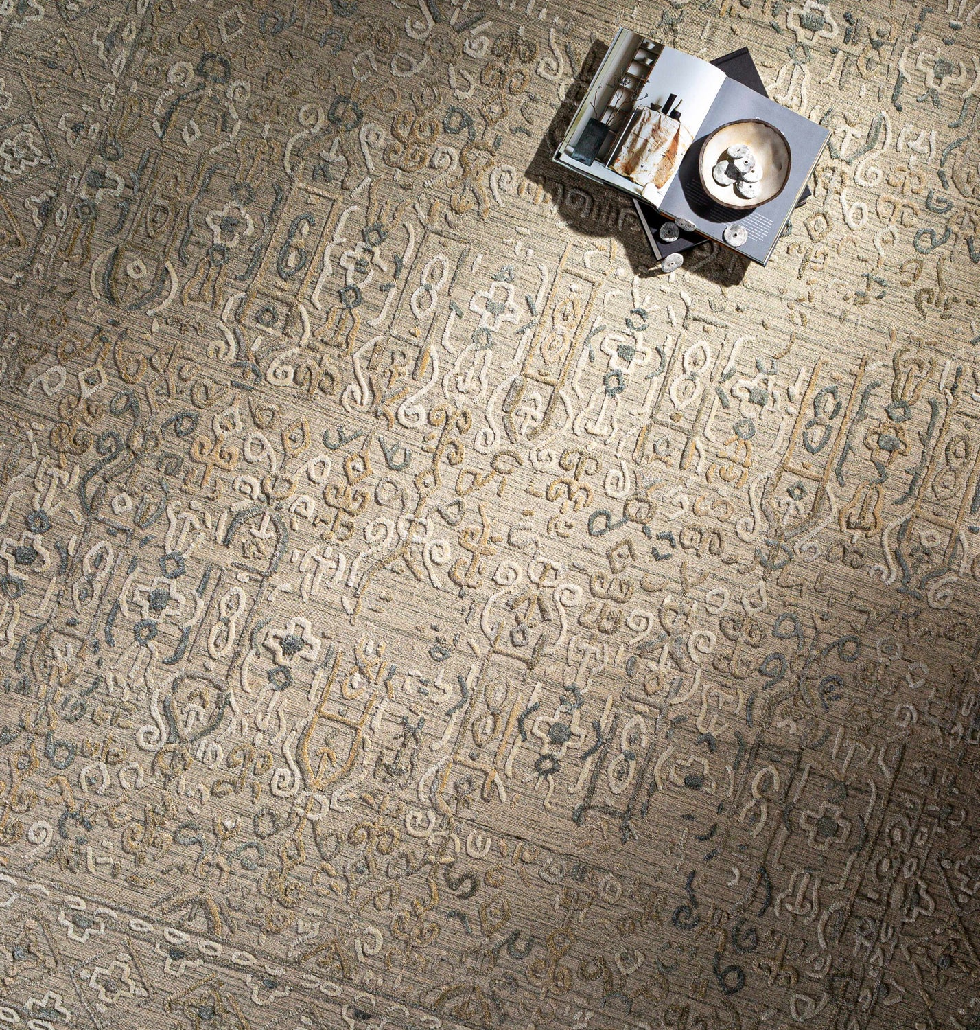 Close-up of the Dubbo Area Rug showing beige, charcoal, and oatmeal hues with a subtle, hand-loomed bohemian pattern. Styleshot