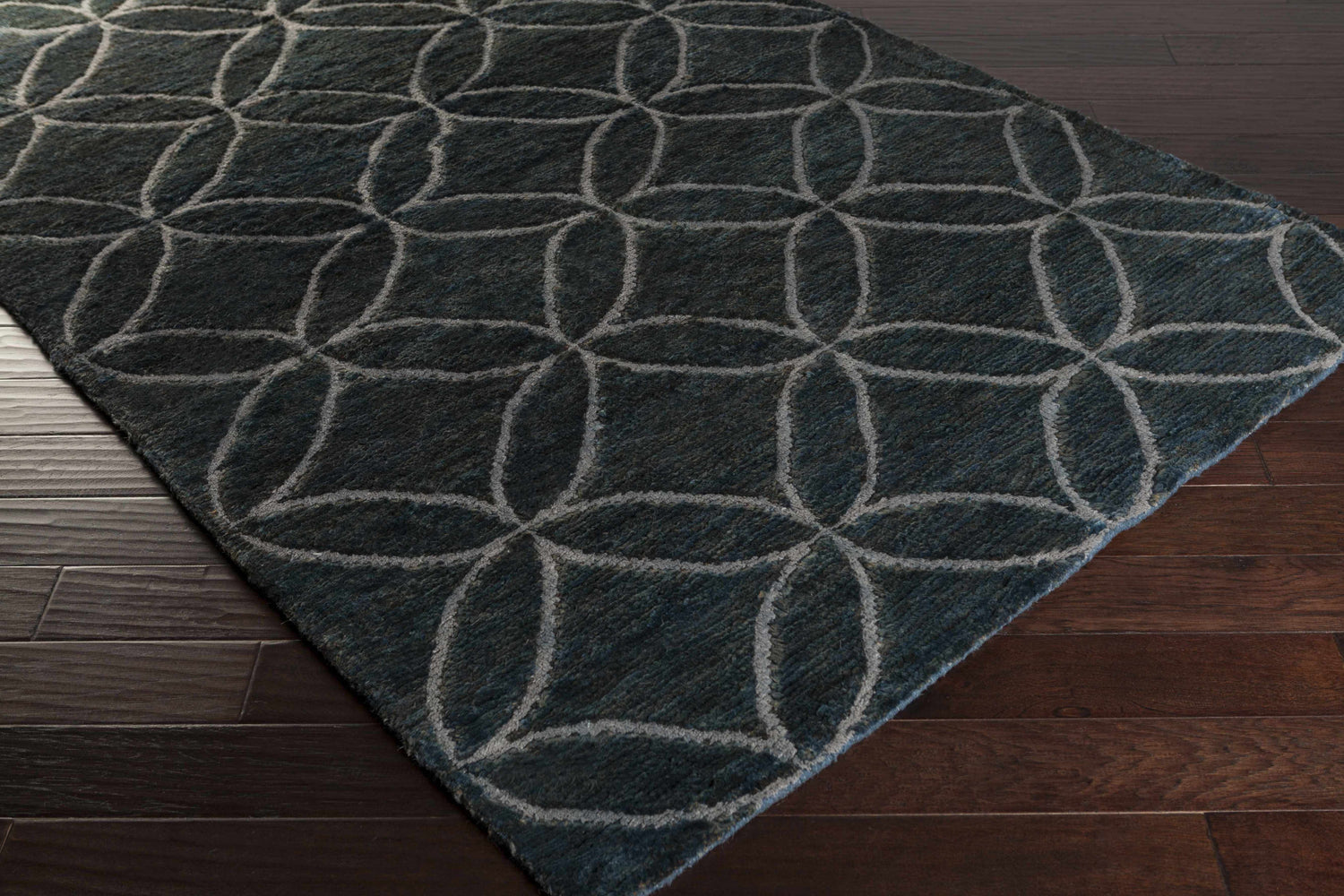 Close-up of the Duson Area Rug showing its ice blue, ink blue, and sage geometric circle pattern and wool texture. Corner