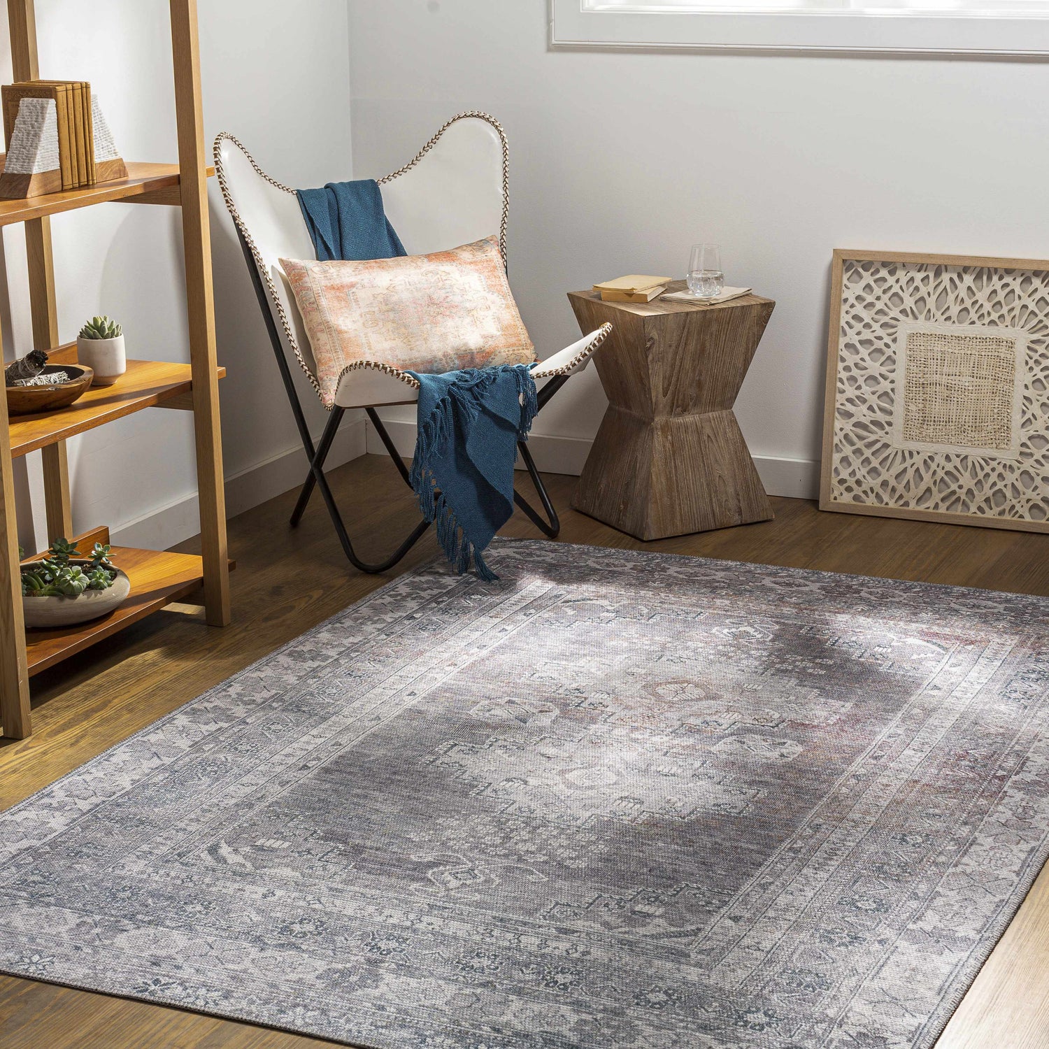 Cozy room scene with a Baltinglass Gray Washable Rug, white chair, wood accents, and a light, airy feel. Roomscene-Rectangle