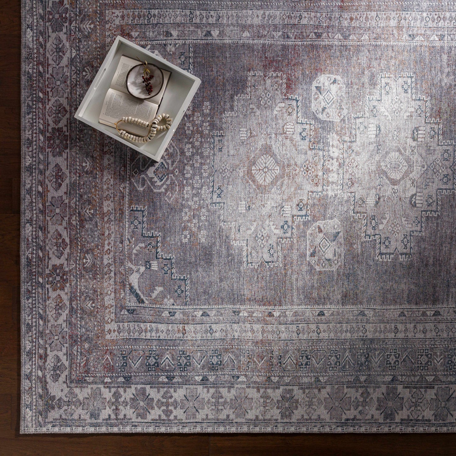 Close-up of the Baltinglass Gray Washable Rug showing its traditional oriental pattern, brown, charcoal, cream, and gray colors. Styleshot