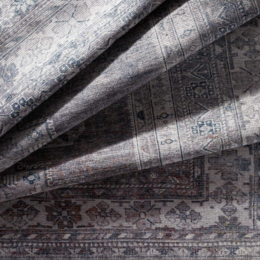 Close-up of the Baltinglass Gray Washable Rug showing its traditional oriental pattern, brown, gray, and cream colors. Fold
