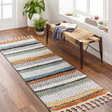 Entryway with a striped Edmundston Area Rug, wood bench, plants, and wood floors. Roomscene-Runner