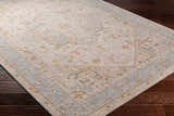 Close-up of the Ehan Cream Thick Luxe Oushak Rug showing its traditional pattern, amber, and dusty pink colors. Corner