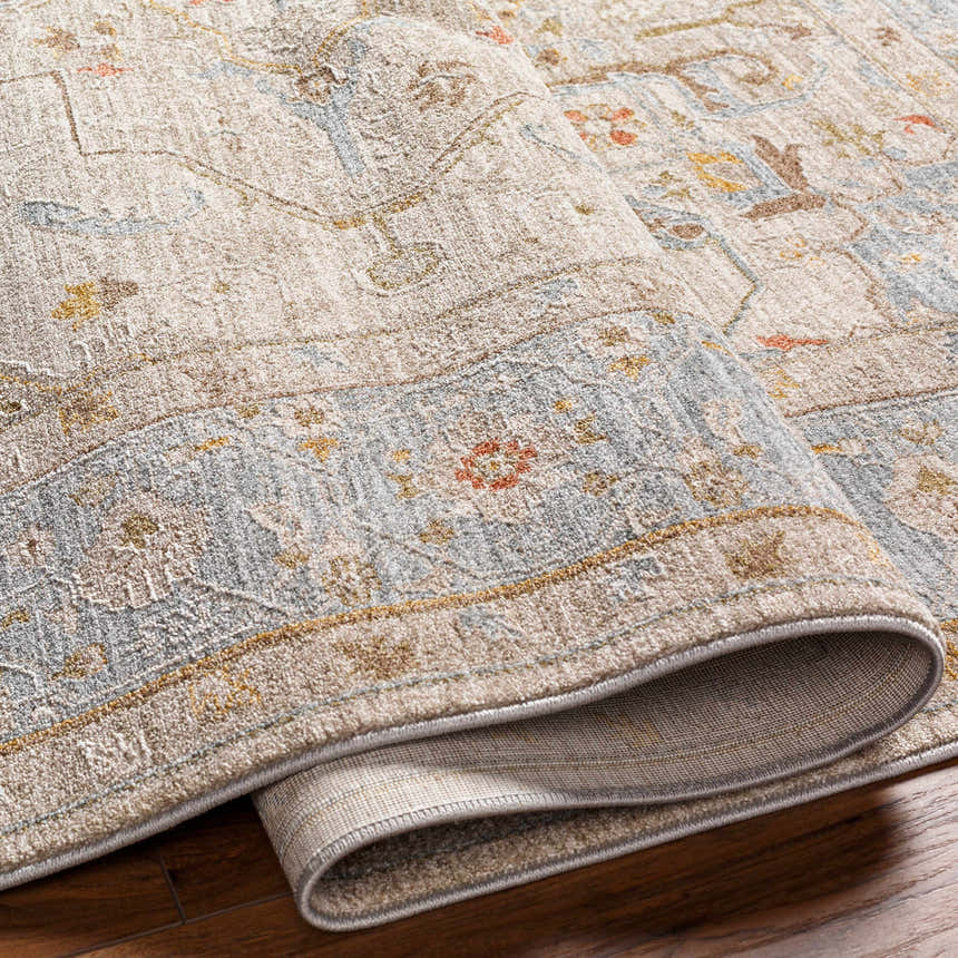 Close-up of the Ehan Cream Thick Luxe Oushak Rug showcasing its traditional pattern, amber, and dusty pink colors. Soft texture visible. Fold