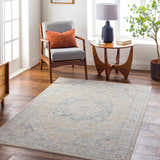 Living room scene with the Ehan Cream Thick Luxe Oushak Rug, gray chair, wood accents, and natural light. Farmhouse style. Roomscene-Rectangle