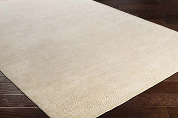 Close-up of the Elco Clearance Rug. Hand-knotted rug in medium gray and wheat with subtle striped texture. Corner