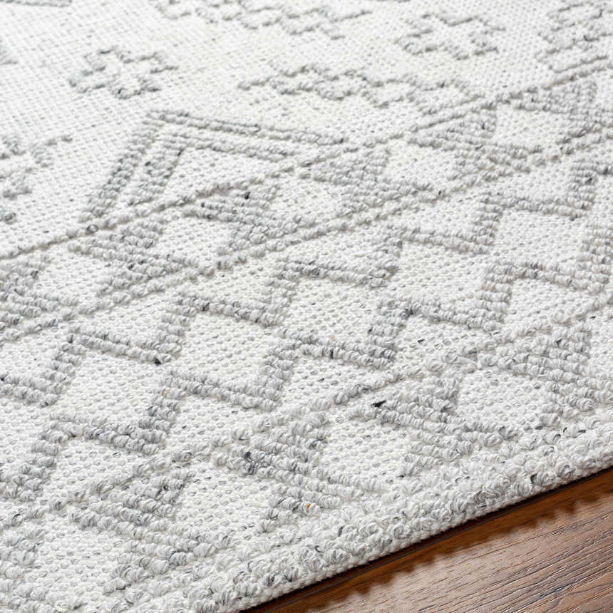 Close-up of the Elin Area Rug showing its hand-woven texture and geometric pattern in arctic stone and dark gray. Texture