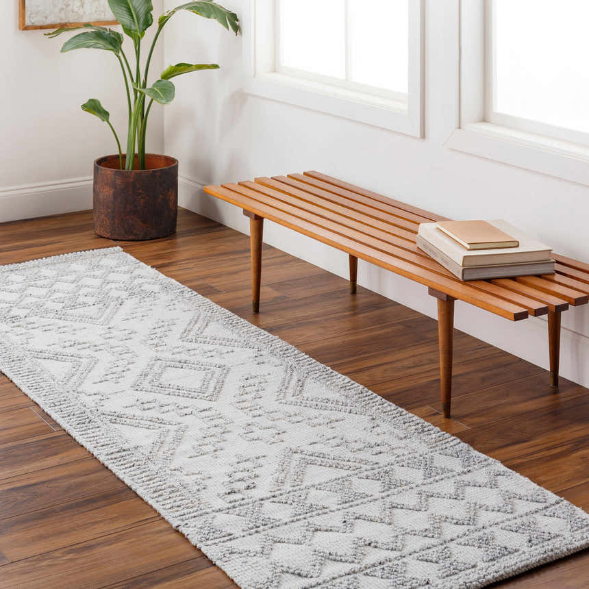 Hallway scene with Elin Area Rug runner in arctic stone. Wood bench, plant, and dark wood floors. Roomscene-Runner