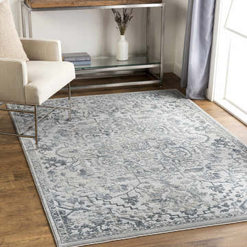 Living room scene with Embsay Teal Boutique Rug, beige chair, wood floors, silver console table, and natural light. Roomscene-Rectangle