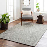 Living room scene with Eriline Wool & Faux Silk Rug in denim and ivory, gray chair, wood floors, and natural light. Roomscene-Rectangle