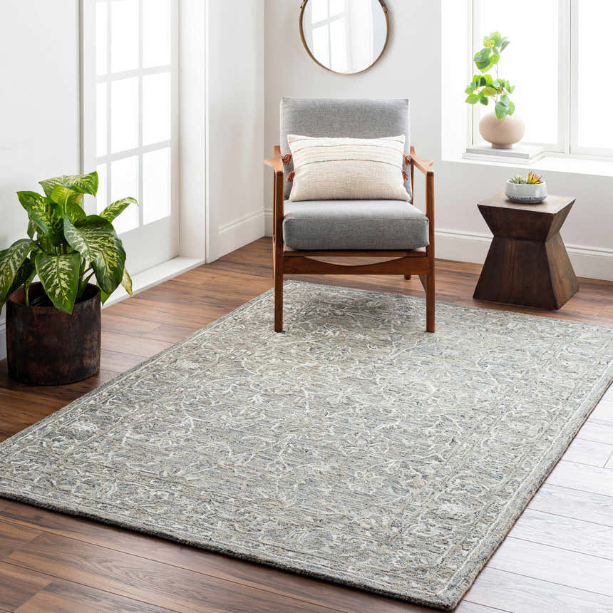 Living room scene with Eriline Wool & Faux Silk Rug in denim and ivory, gray chair, wood floors, and natural light. Roomscene-Rectangle