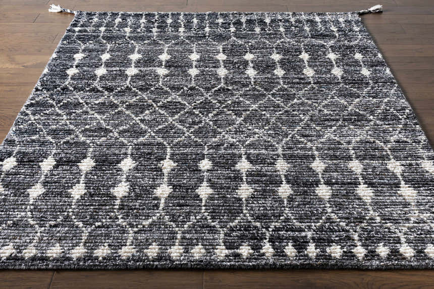 Close-up of Erina Premium Rug - Clearance. Hand-knotted rug with a black, charcoal, and cream geometric pattern. Front