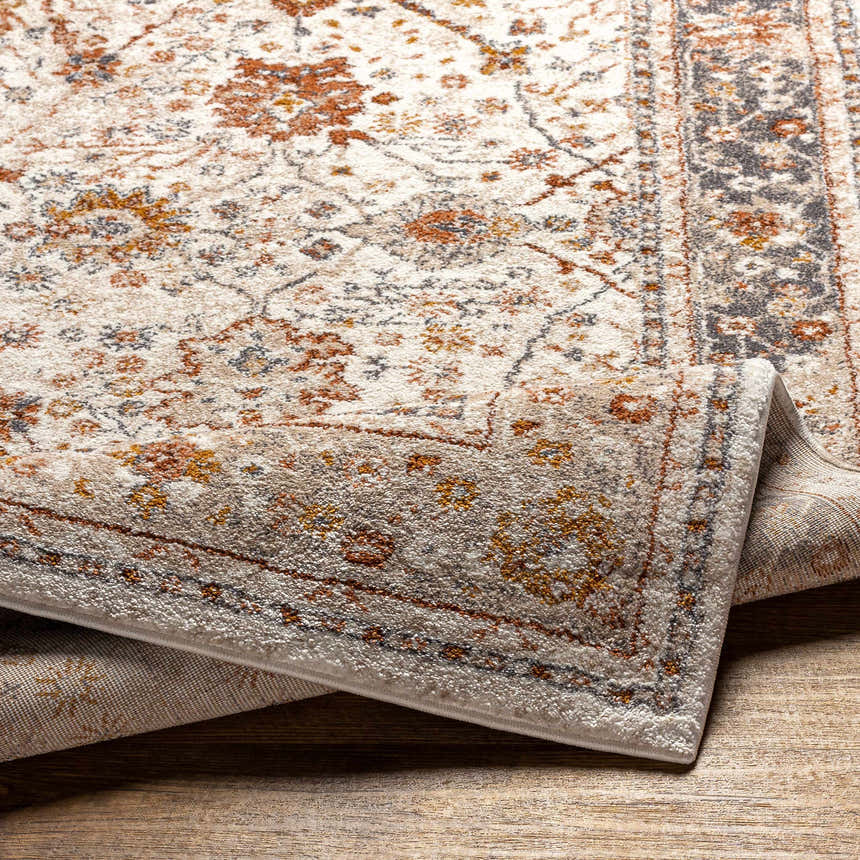Close-up of the Paatan Luxe Floral Oushaq Area Rug featuring a traditional floral pattern in cream, rust, and gray tones. Fold