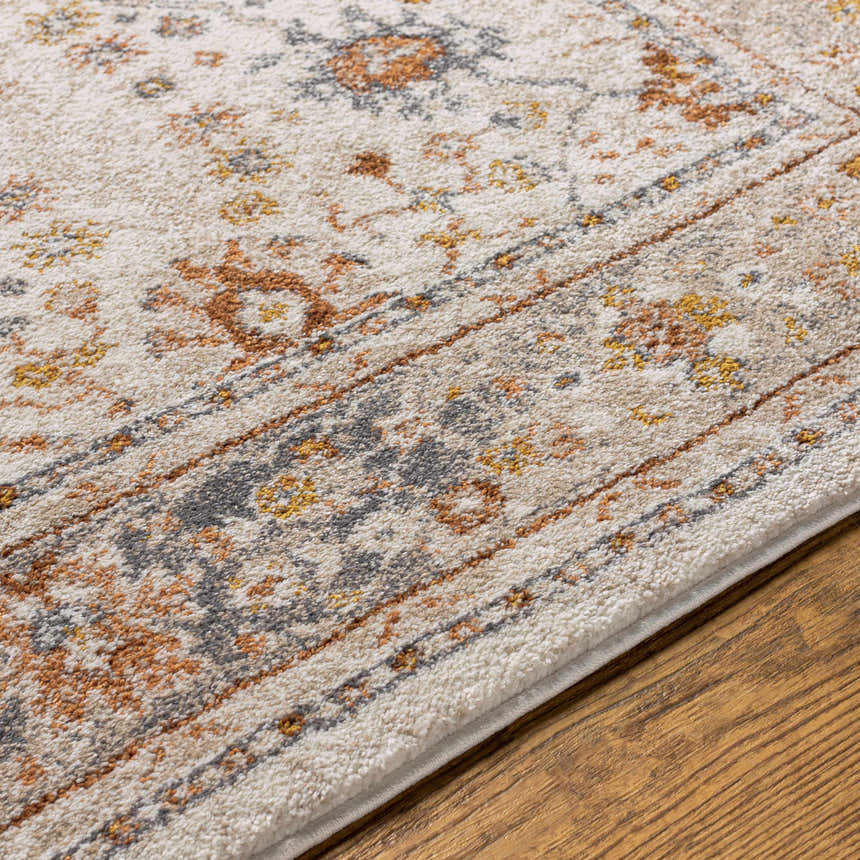 Close-up of the Paatan Luxe Floral Oushaq Area Rug showing its floral pattern, soft texture, and neutral colors on a wood floor. Texture
