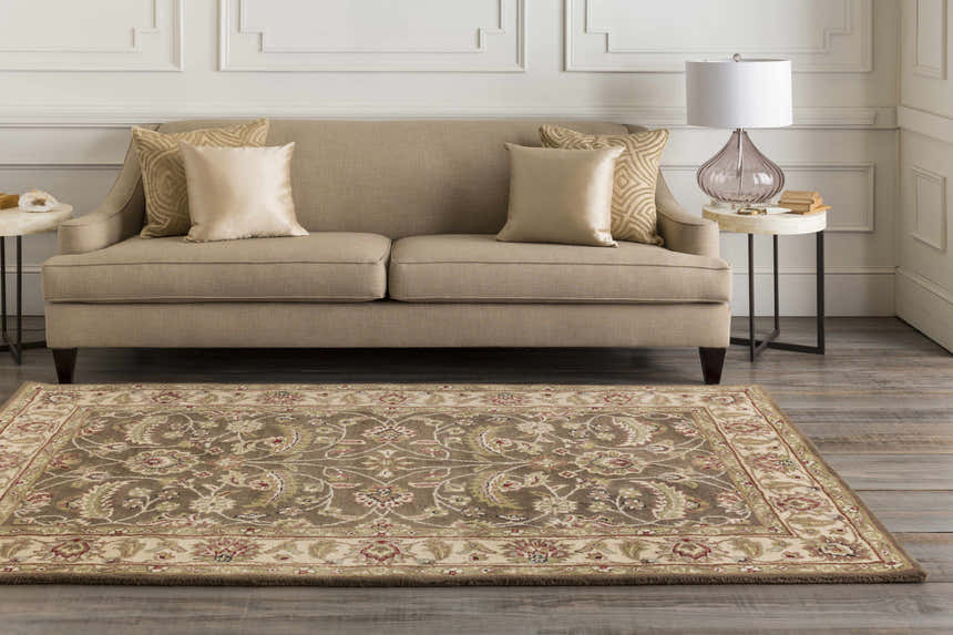 Living room scene with a beige sofa and floral Eupora Wool Rug in brown, red, and olive tones. Roomscene-Rectangle