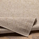 Close-up of the Maunawili Cream Nordic Rug showing its woven texture and subtle geometric pattern in beige and light brown. Fold