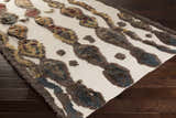 Close-up of the Brown Mustard Nila Carpet showing its shag texture and geometric pattern in brown, beige, and navy. Corner