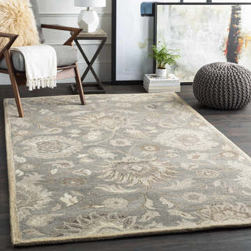 Living room scene with a Conesus 1195 ivory and taupe wool rug, gray chair, ottoman, and dark wood floors. Roomscene-Rectangle