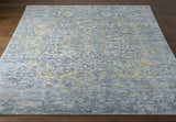 Close-up of the hand-knotted Farmingville Area Rug. Oriental design in blue, sage, beige, and tan on dark wood floors. Front
