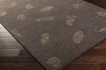 Close-up of Fayette Carpet Area Rug in taupe with beige seashell pattern on dark wood floor. Hand-knotted wool rug. Corner