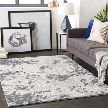 Living room scene with a denim and ivory Fence Area Rug, gray sofa, and modern art. Roomscene-Rectangle