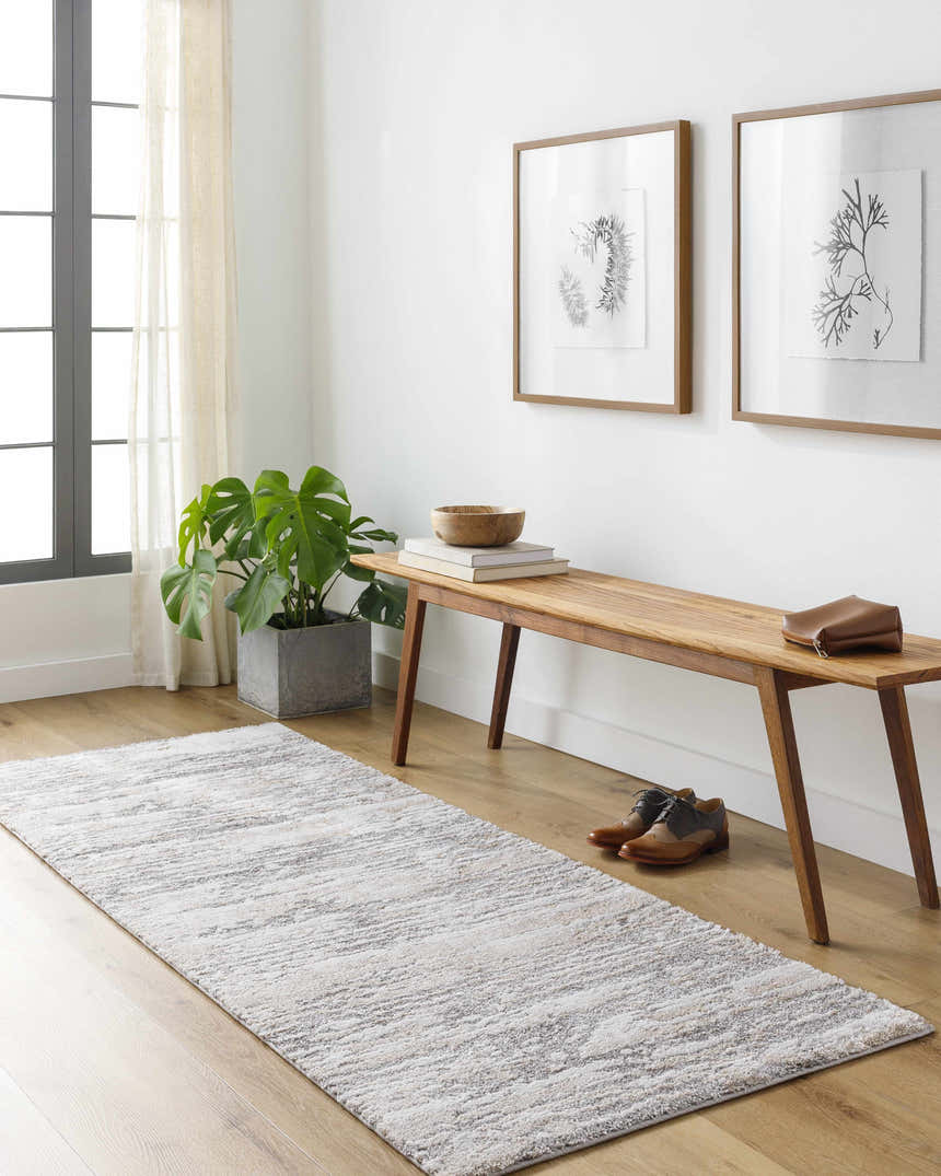 Entryway with light wood floors and Ferrelview runner rug in gray, ivory and tan under a wooden bench. Roomscene-Runner